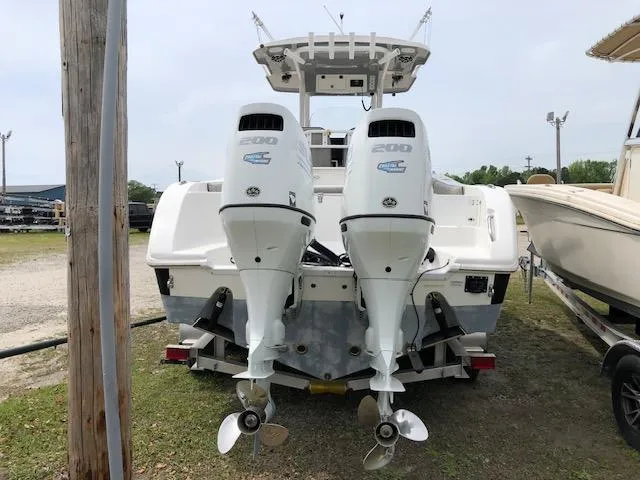 Slide: The Image of 2021 Sea Pro 259 DLX boat with dual outboard engines, parked on grass. - 5