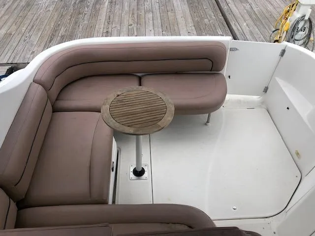 Slide: The Image of Bayliner 3055 Ciera 2000 boat interior with cushioned seating and wooden table. - 11