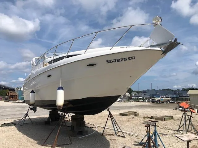 Slide: The Image of 2000 Bayliner 3055 Ciera boat on stands, clear sky background. - 2