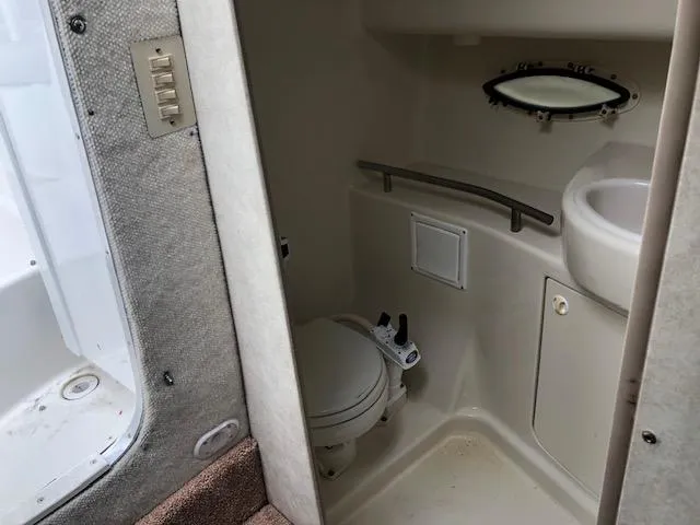 Slide: The Image of Bayliner 3055 Ciera 2000 boat bathroom with toilet, sink, and porthole window. - 23