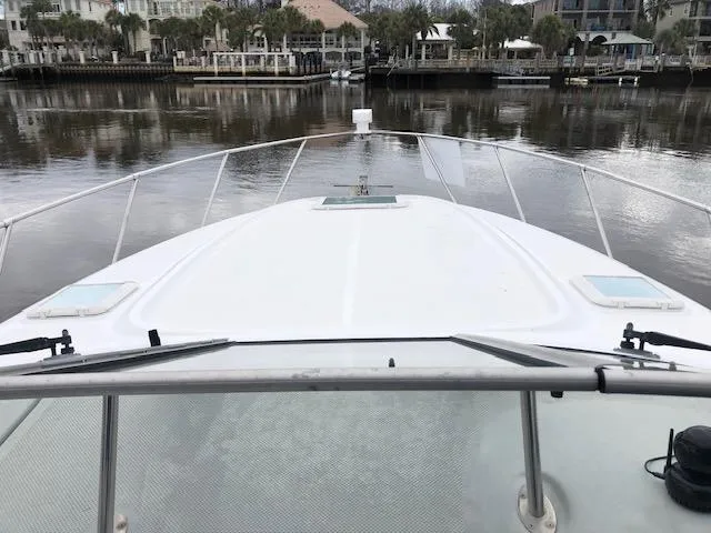 Slide: The Image of Bayliner 3055 Ciera 2000 model boat on calm water near a marina. - 25