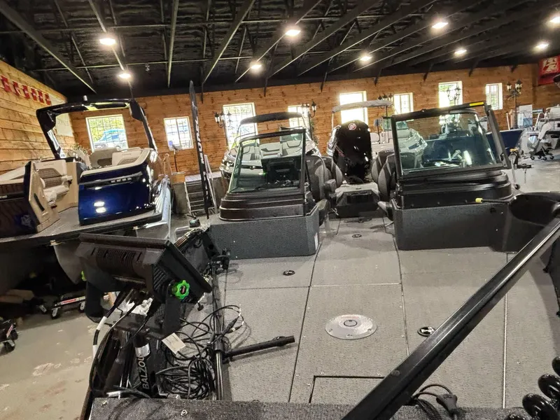 Slide: The Image of 2025 Lund 2025 Impact XS Sport boat displayed in a showroom with modern interior. - 11