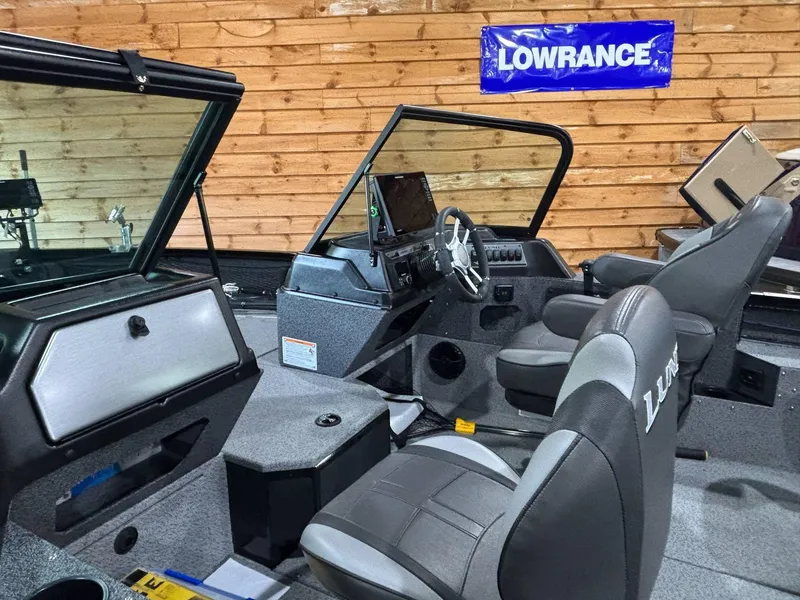 Slide: The Image of 2025 Lund 2025 Impact XS Sport boat interior with Lowrance equipment, featuring modern seating and dashboard. - 17