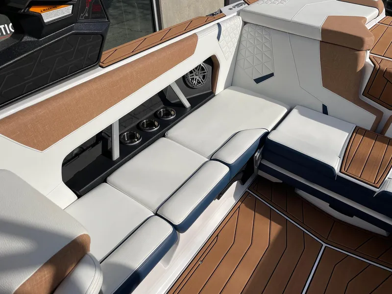 Slide: The Image of 2024 Nautique Super Air Nautique GS22 interior with white and tan seating, cup holders, and stylish design. - 7