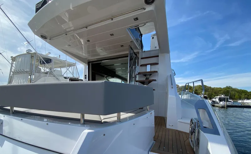 Slide: The Image of 2022 Cruisers Yachts 60 Fly, luxury yacht exterior with stairs and seating area. - 14