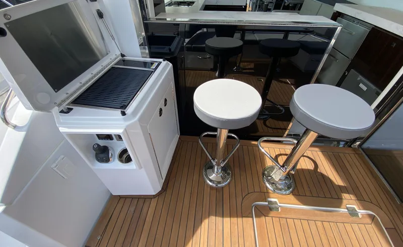Slide: The Image of Luxurious 2022 Cruisers Yachts 60 Fly deck with bar stools and grill. - 17
