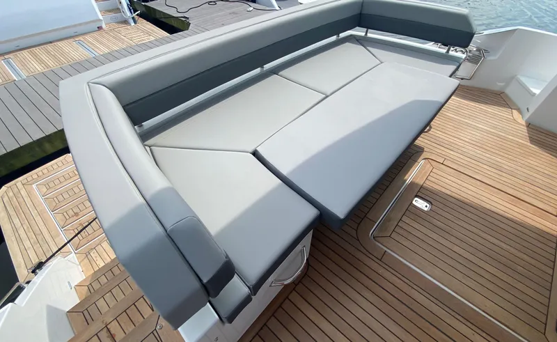 Slide: The Image of Luxurious seating area on 2022 Cruisers Yachts 60 Fly, featuring sleek design and wooden deck. - 21