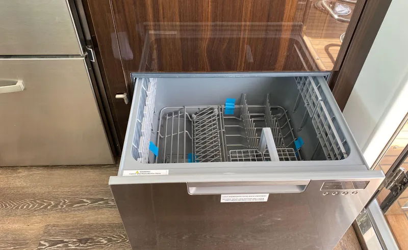 Slide: The Image of Open dishwasher drawer on 2022 Cruisers Yachts 60 Fly, featuring modern interior design. - 26