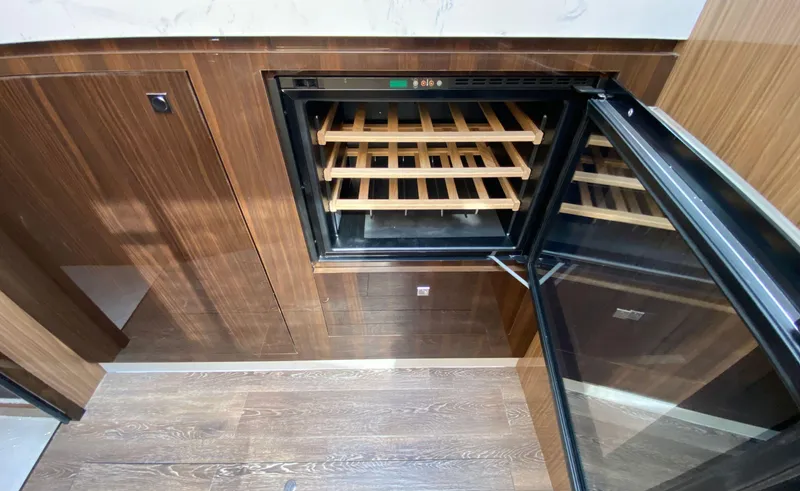 Slide: The Image of Luxury yacht interior with open wine cooler, wooden finish, Cruisers Yachts 60 Fly 2022 model. - 40