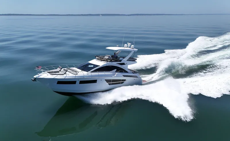 Slide: The Image of 2022 Cruisers Yachts 60 Fly cruising on calm waters, creating a dynamic wake. - 1