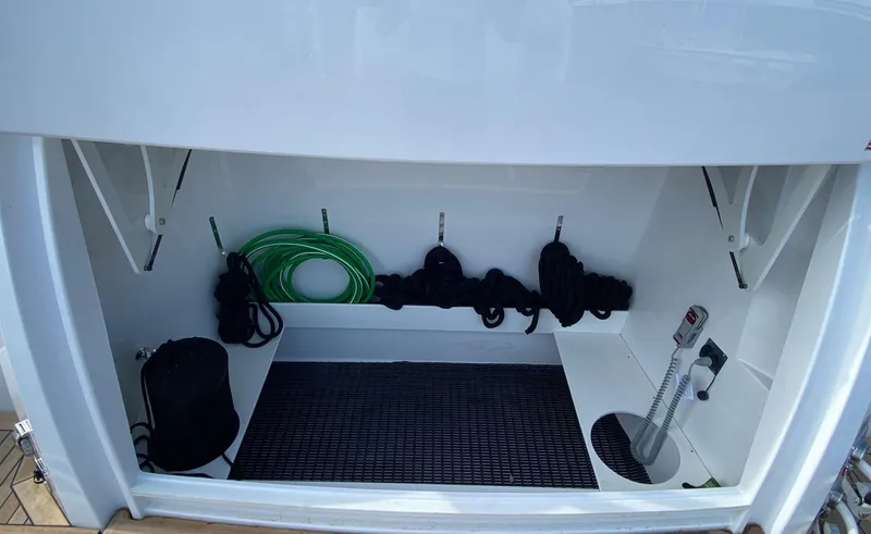 Slide: The Image of Storage compartment of 2022 Cruisers Yachts 60 Fly with ropes and hose. - 11