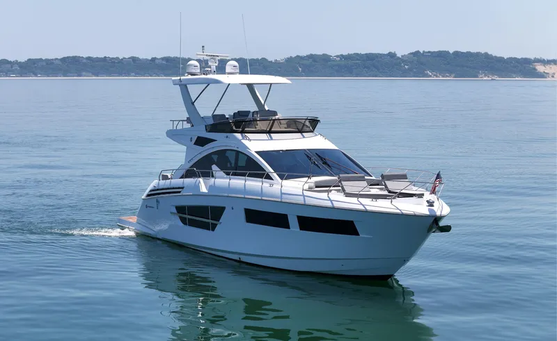 Slide: The Image of 2022 Cruisers Yachts 60 Fly on calm water, showcasing sleek design and luxury features. - 2