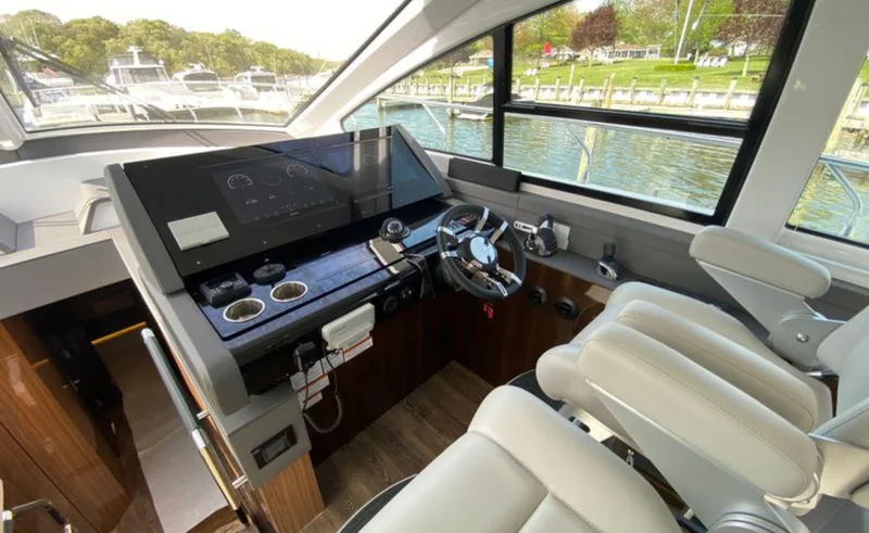 Slide: The Image of Interior helm of 2022 Cruisers Yachts 60 Fly, featuring modern controls and luxurious seating. - 34