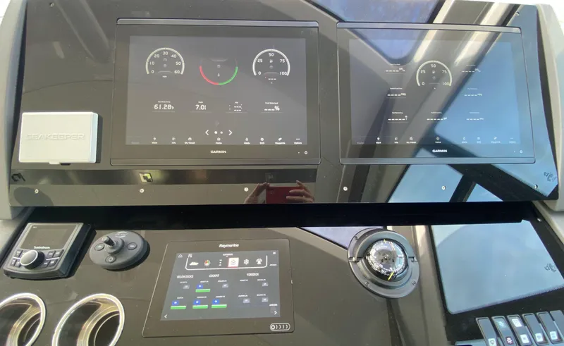 Slide: The Image of Control panel of 2022 Cruisers Yachts 60 Fly with digital displays and navigation instruments. - 35