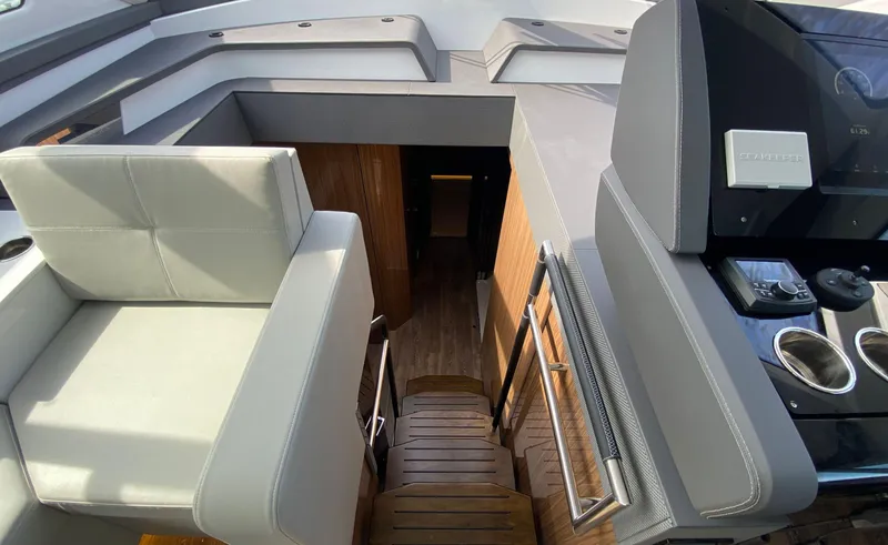 Slide: The Image of Interior view of 2022 Cruisers Yachts 60 Fly, featuring modern seating and control panel. - 37