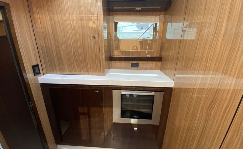 Slide: The Image of Luxurious 2022 Cruisers Yachts 60 Fly kitchen with wood cabinetry and modern appliances. - 39
