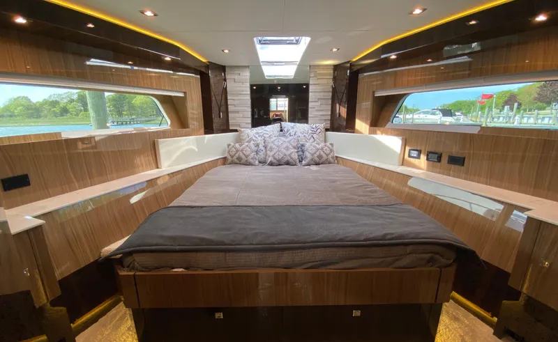 Slide: The Image of Luxurious bedroom interior of 2022 Cruisers Yachts 60 Fly with elegant wood finish and scenic windows. - 44
