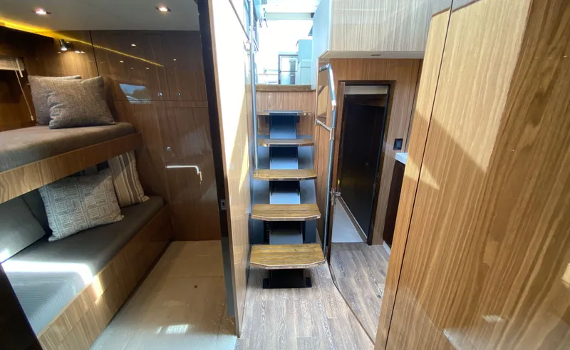 Slide: The Image of Interior of 2022 Cruisers Yachts 60 Fly, featuring wooden finishes and bunk beds. - 49
