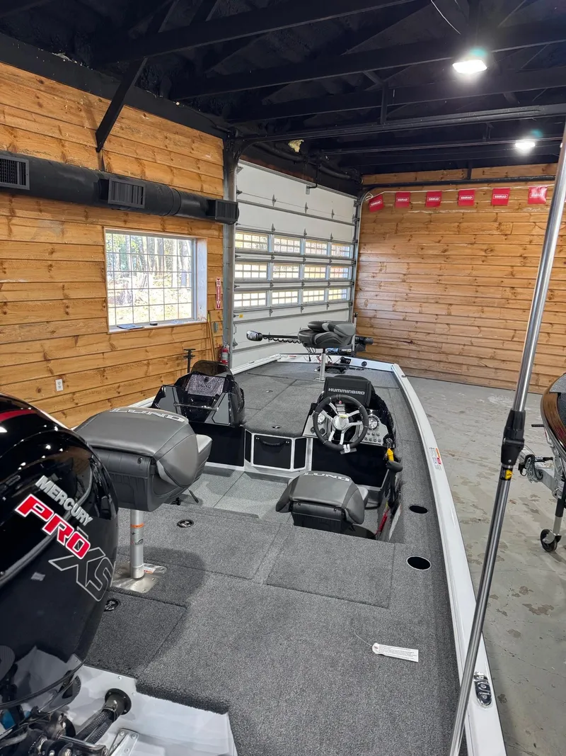 Slide: The Image of 2025 Lund 1975 Renegade SS boat in a wooden garage, featuring modern interior and powerful engine. - 3