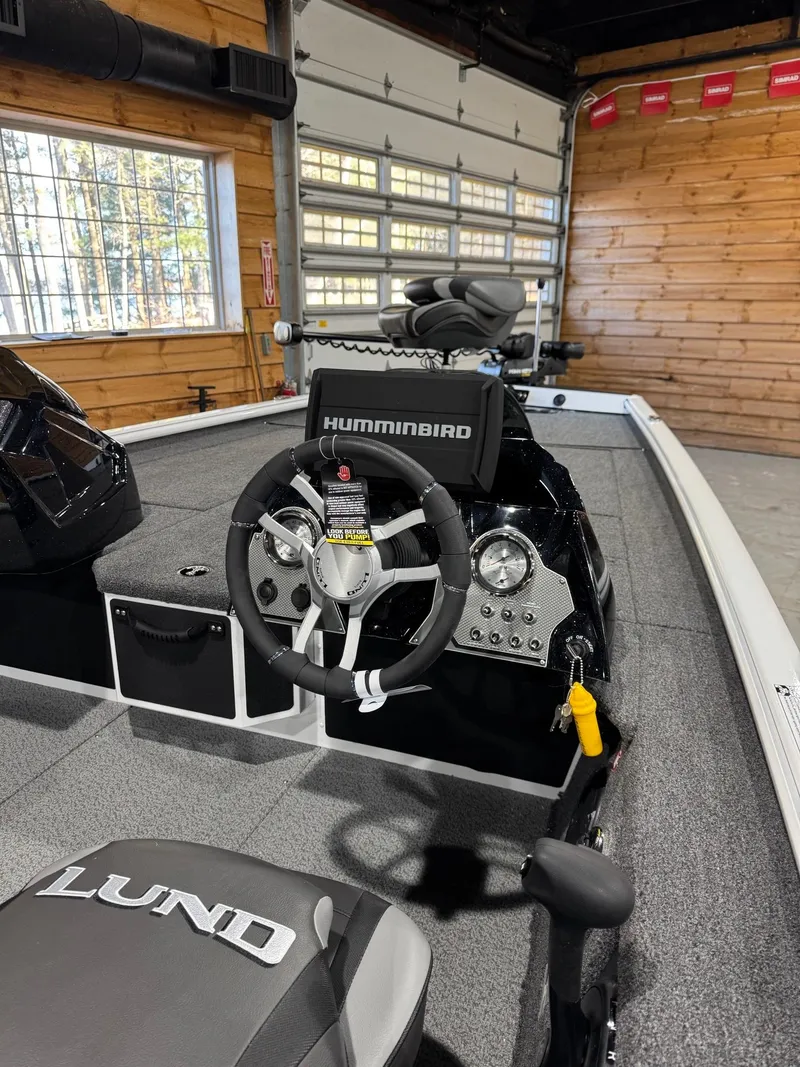 Slide: The Image of Interior of 2025 Lund 1975 Renegade SS boat with steering wheel and Humminbird electronics. - 6