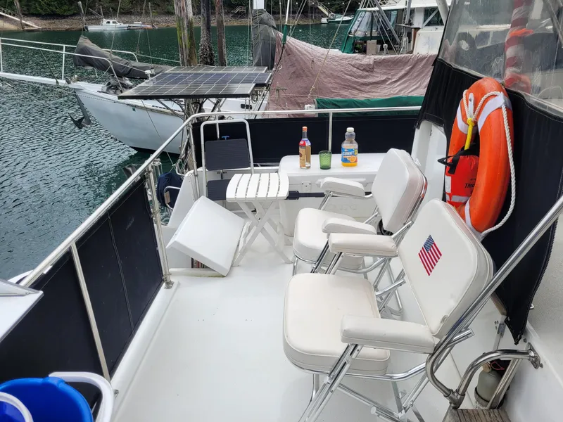 Slide: The Image of 1991 Tollycraft Euro Sport Sedan deck with chairs, table, and life preserver. - 15