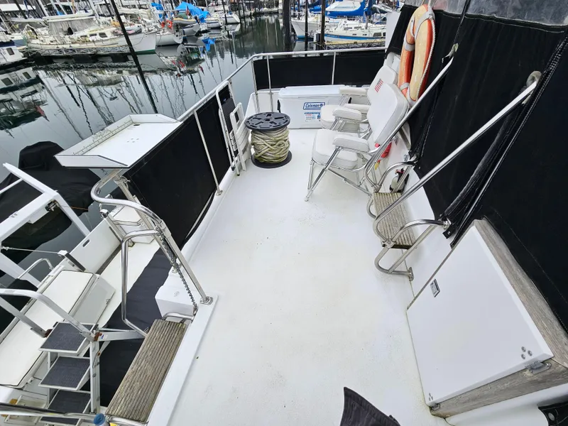 Slide: The Image of 1991 Tollycraft Euro Sport Sedan deck with chairs and marina view. - 16