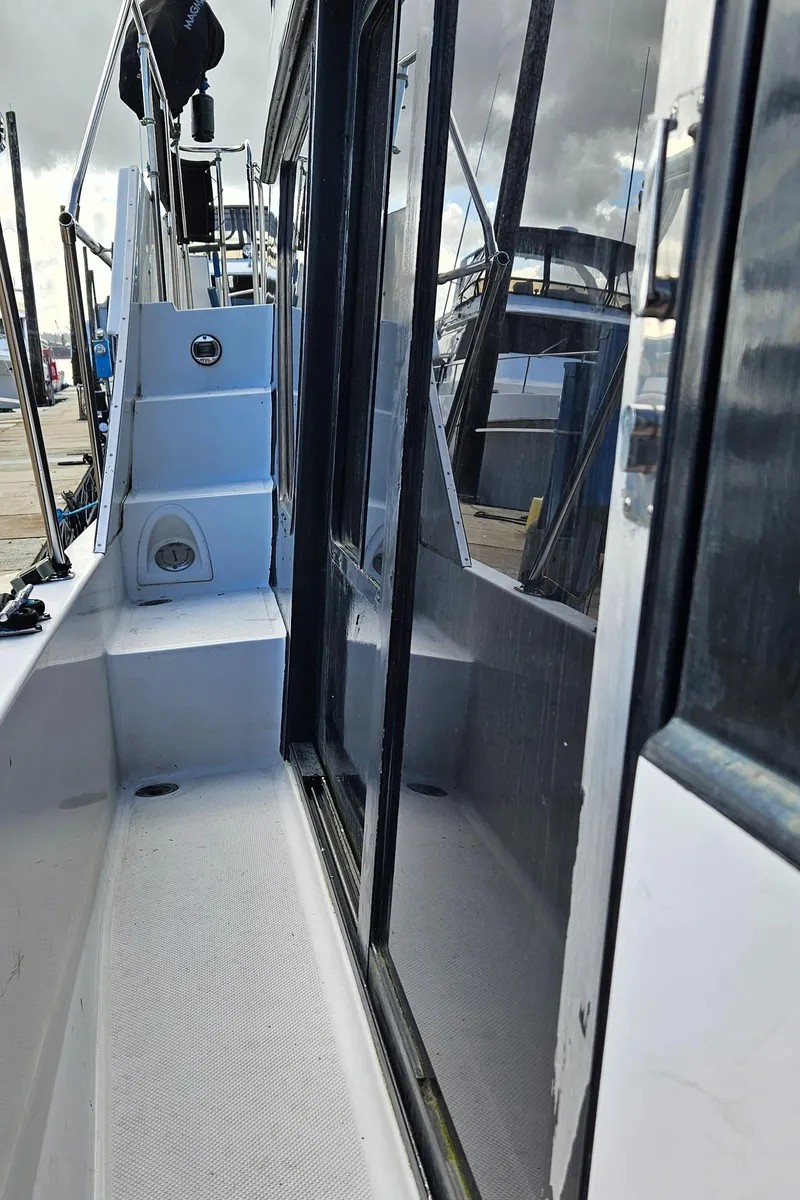 Slide: The Image of 1991 Tollycraft Euro Sport Sedan boat deck with sleek design and reflective windows. - 17