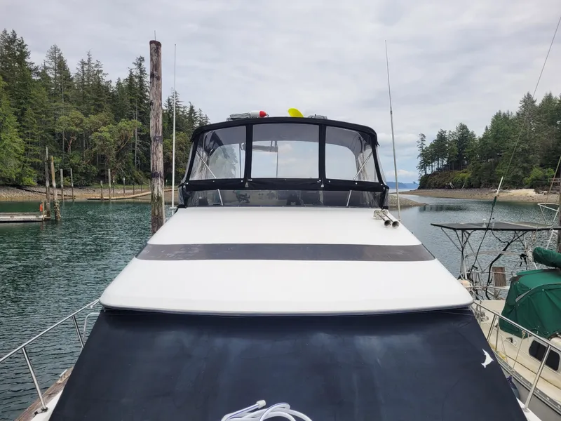 Slide: The Image of 1991 Tollycraft Euro Sport Sedan docked in scenic marina with forested backdrop. - 2