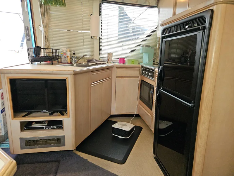 Slide: The Image of Interior of a 1991 Tollycraft Euro Sport Sedan with kitchen and appliances. - 29