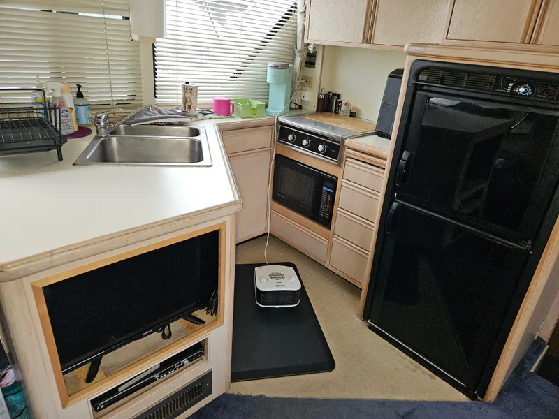 Slide: The Image of Interior of 1991 Tollycraft Euro Sport Sedan kitchen with sink, stove, and refrigerator. - 31