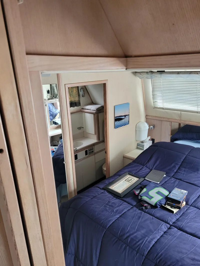 Slide: The Image of 1991 Tollycraft Euro Sport Sedan cabin with blue bedding and cozy interior. - 36