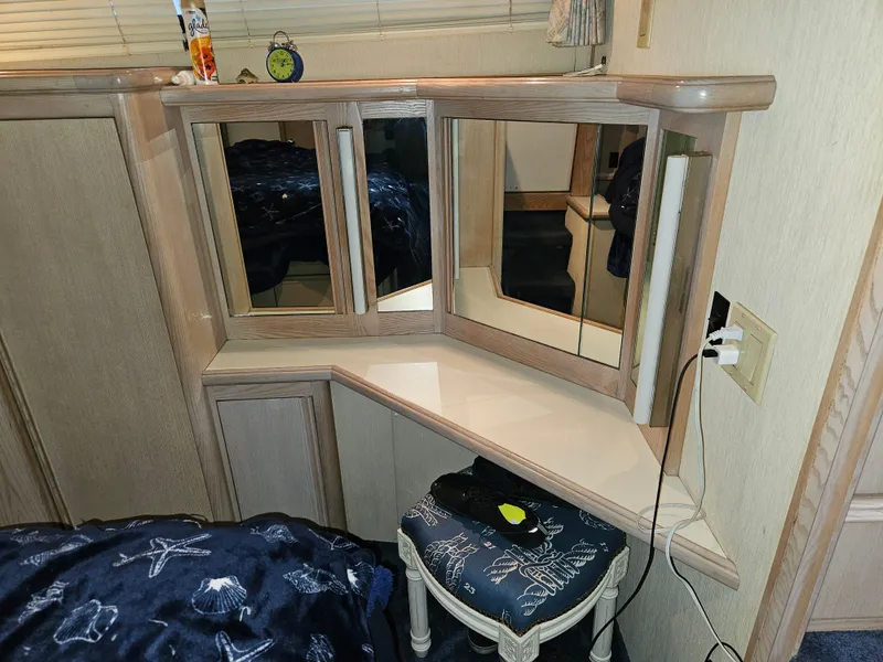 Slide: The Image of 1991 Tollycraft Euro Sport Sedan interior with mirrored vanity and nautical-themed stool. - 38