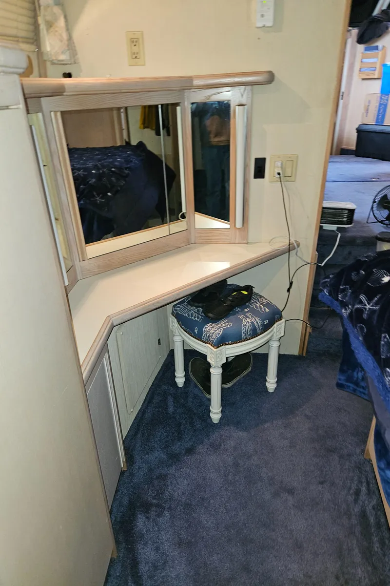 Slide: The Image of 1991 Tollycraft Euro Sport Sedan interior with vanity and stool, featuring blue carpet. - 39