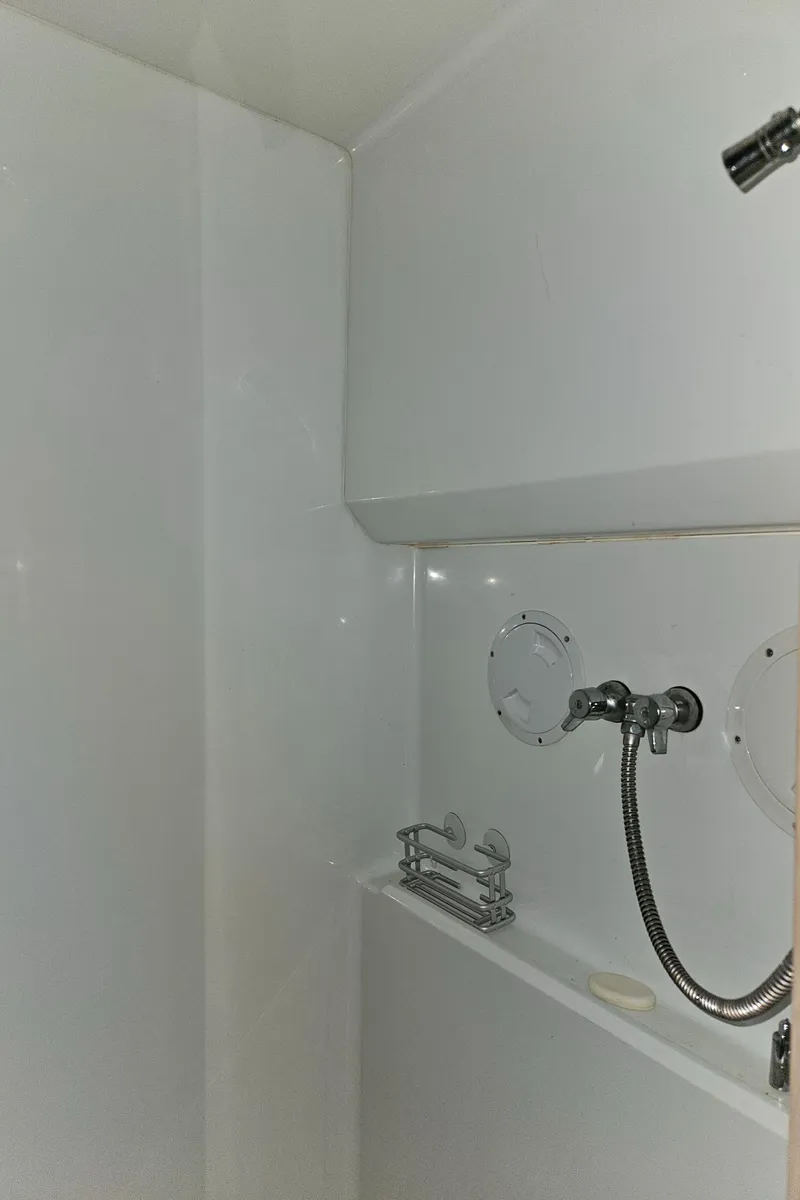 Slide: The Image of 1991 Tollycraft Euro Sport Sedan shower area with white walls and chrome fixtures. - 42