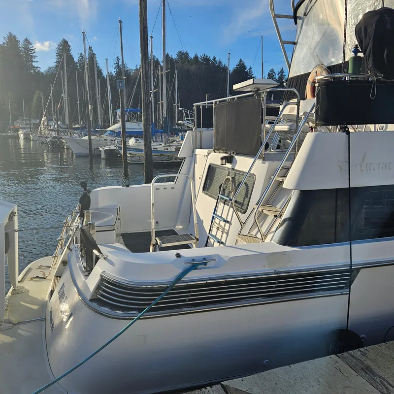 Slide: The Image of 1991 Tollycraft Euro Sport Sedan docked at marina with sailboats in background. - 8