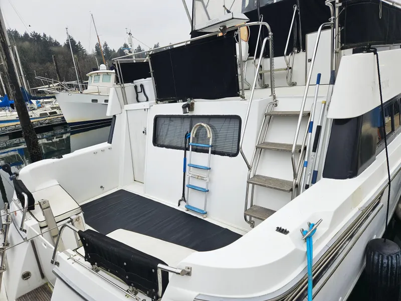 Slide: The Image of 1991 Tollycraft Euro Sport Sedan yacht docked, featuring a spacious deck and ladder access. - 9