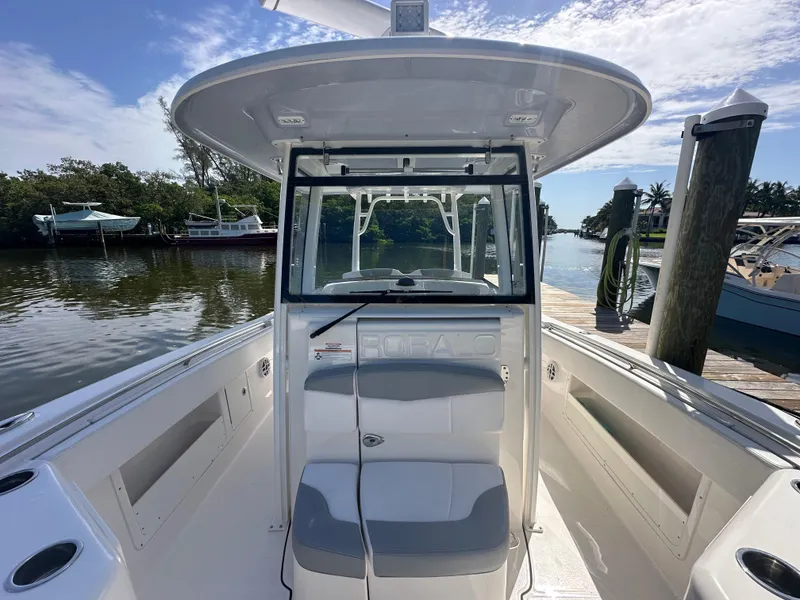 Slide: The Image of 2021 Robalo R302 Center Console boat docked by a scenic waterfront. - 13