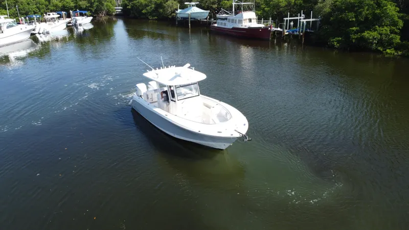 Slide: The Image of 2021 Robalo R302 Center Console boat cruising in a serene waterway. - 2