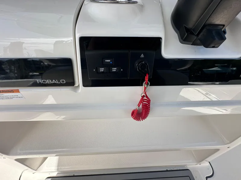 Slide: The Image of 2021 Robalo R302 Center Console dashboard with ignition and red safety lanyard. - 20