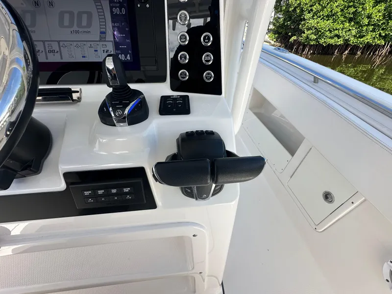 Slide: The Image of 2021 Robalo R302 Center Console boat dashboard with controls and display. - 26