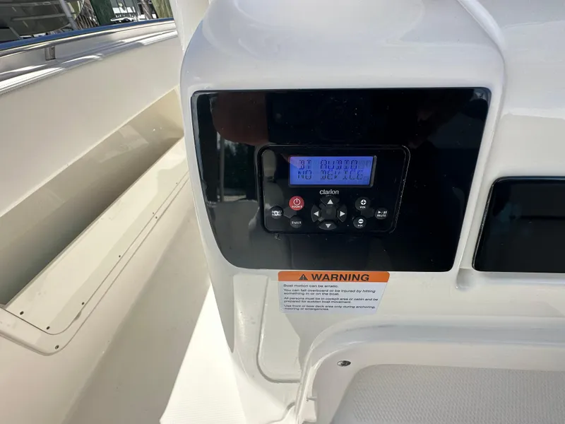 Slide: The Image of 2021 Robalo R302 Center Console boat dashboard with control panel and warning label. - 31