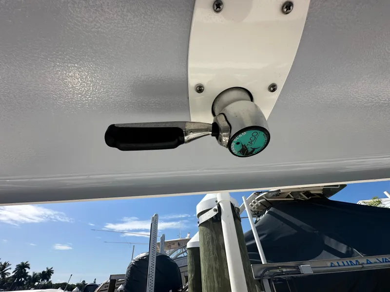Slide: The Image of Robalo R302 Center Console 2021 boat detail with lever handle, docked under clear sky. - 34