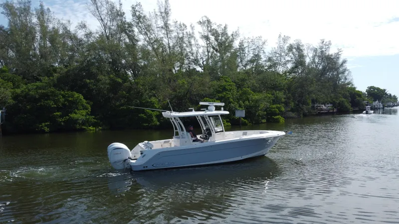Slide: The Image of 2021 Robalo R302 Center Console boat cruising on a scenic waterway. - 4