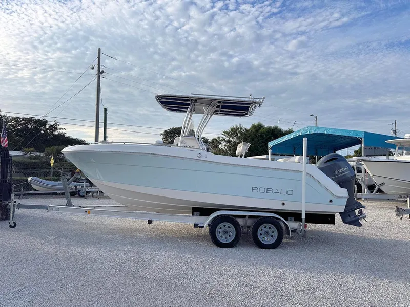 Slide: The Image of 2016 Robalo R222 Center Console boat on trailer, parked outdoors under cloudy sky. - 4