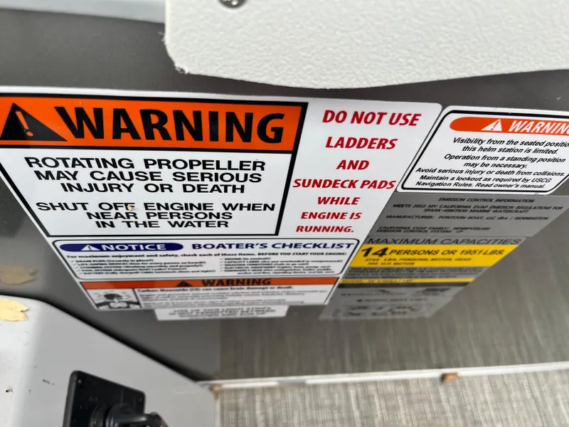 Slide: The Image of Warning labels on 2024 Bennington 25LTFB boat, highlighting safety precautions and capacity limits. - 14