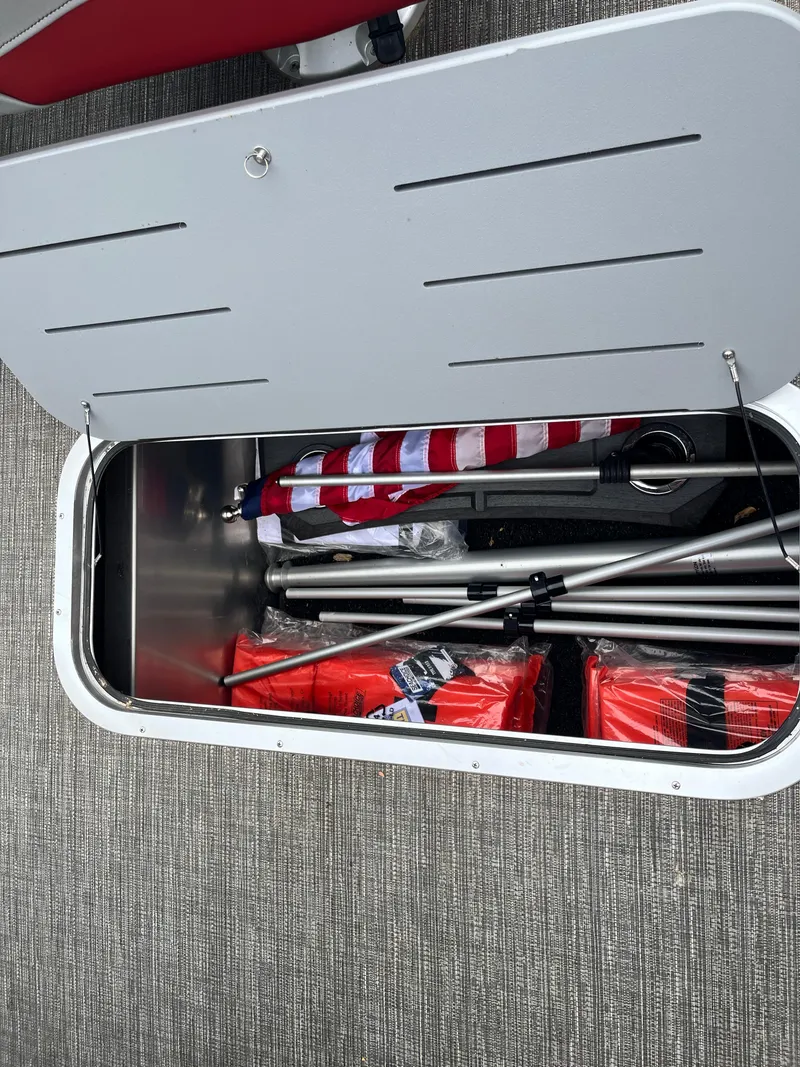 Slide: The Image of Storage compartment of 2024 Bennington 25LTFB boat with safety gear and flag. - 15