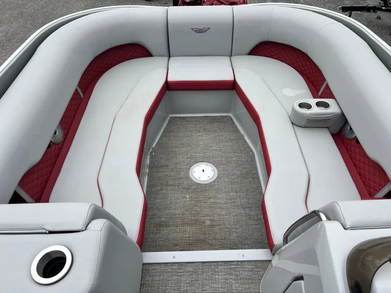 Slide: The Image of 2024 Bennington 25LTFB boat interior with red and gray seating, cup holders, and carpeted floor. - 4