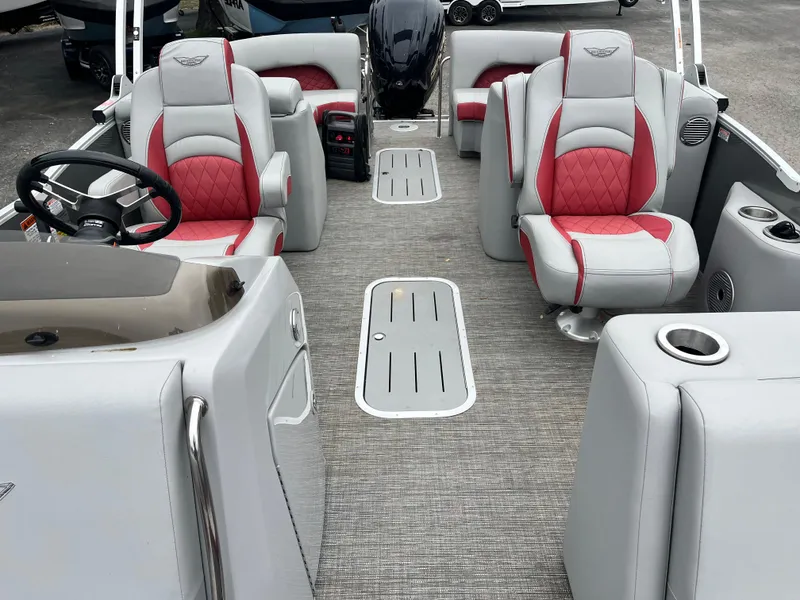 Slide: The Image of 2024 Bennington 25LTFB boat interior with red and gray seating, steering wheel, and carpeted floor. - 5