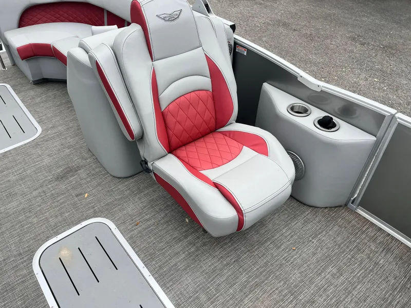 Slide: The Image of 2024 Bennington 25LTFB boat interior with red and gray seating and cup holders. - 6