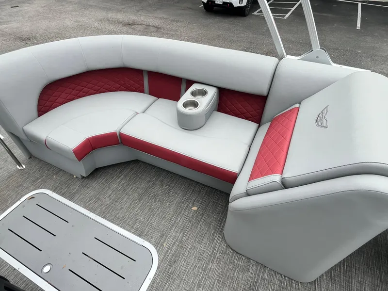 Slide: The Image of 2024 Bennington 25LTFB boat seating with red and gray upholstery, featuring cup holders. - 7